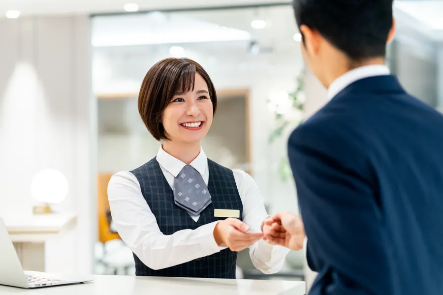 ホテルのフロントで接客するスタッフ
