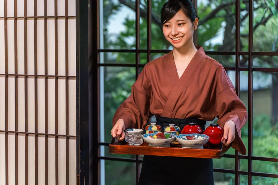 旅館で料理を運ぶスタッフ